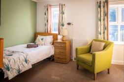 Photo of bedroom with bed, armchair with spring colours 