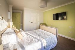 Parkland Bedroom with bed, wall mounted tv and wetroom behind closed door