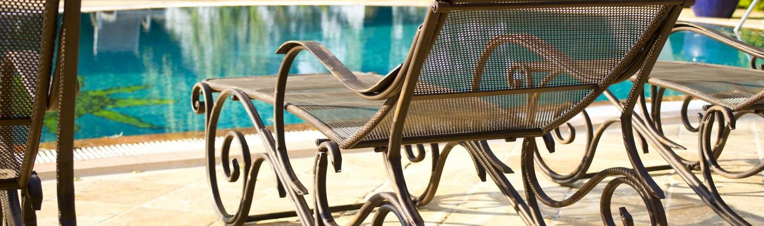 Relaxed-looking wicker sunbeds beside a swimming pool