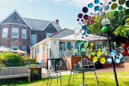 Photo shows Parkland House garden with colourful sculptures